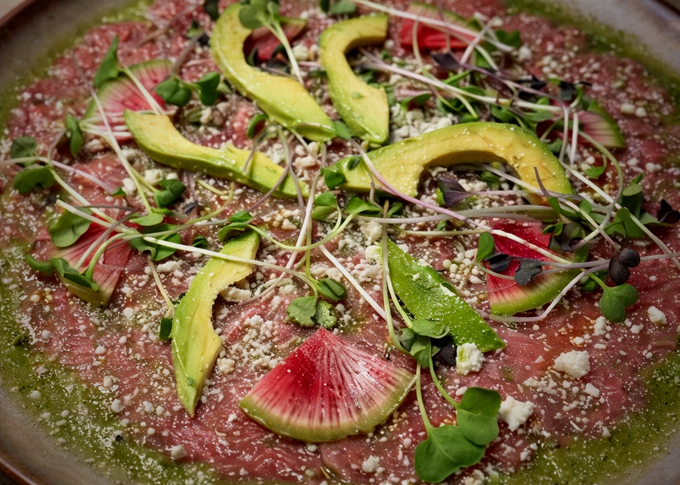 Beef carpaccio with avocado, microgreens, and cotija